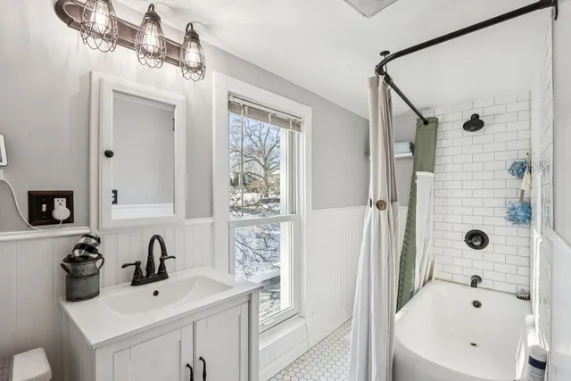 a bathroom with a bathtub a sink and mirror