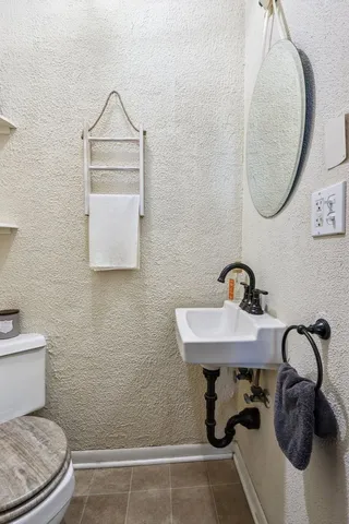a bathroom with a toilet sink and mirror