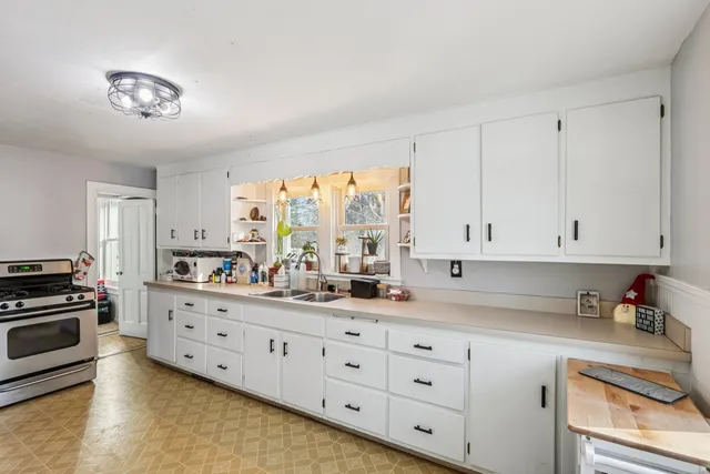 a kitchen with granite countertop white cabinets and stainless steel appliances