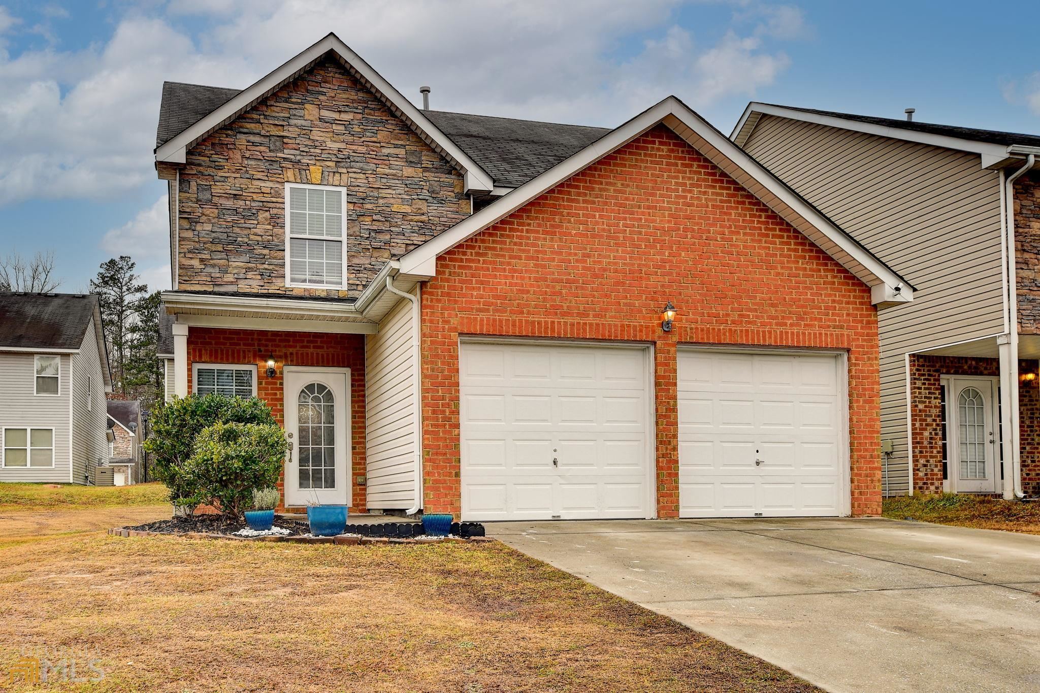 a front view of a house with a yard and garage