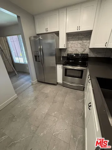 a kitchen with granite countertop a refrigerator and a stove