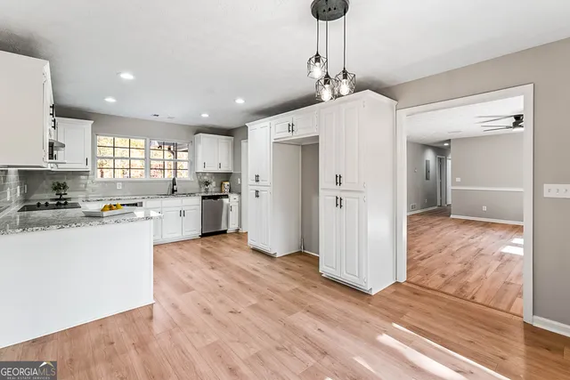 a view of kitchen with granite countertop cabinets and refrigerator