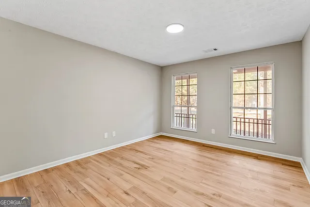 wooden floor in an empty room with a window