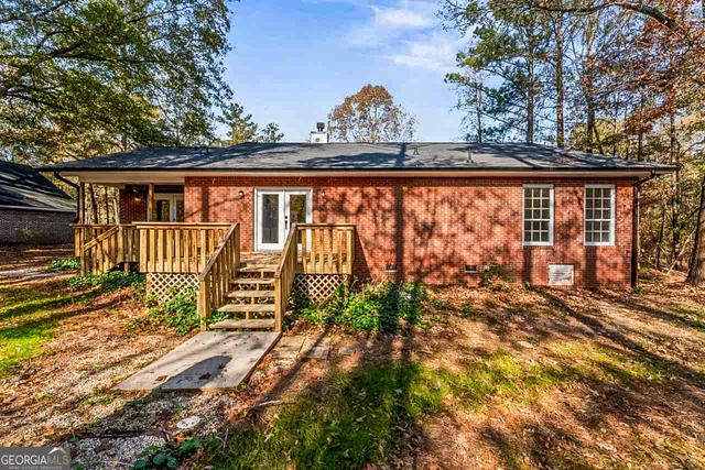 a view of a house with a large window and wooden fence