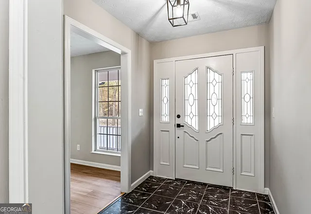 a bathroom with a glass shower door and a window