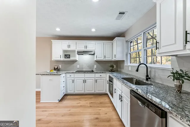 a kitchen with granite countertop white cabinets and white appliances