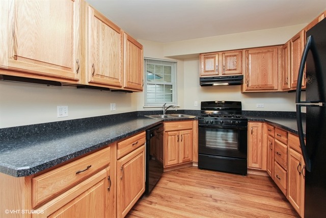 948 Ridgefield Lane Wheeling, IL 60090 - Photo 3 of 10 a kitchen with stainless steel appliances granite countertop a stove a sink and a microwave