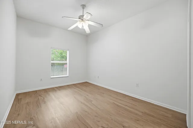 an empty room with a window and wooden floor