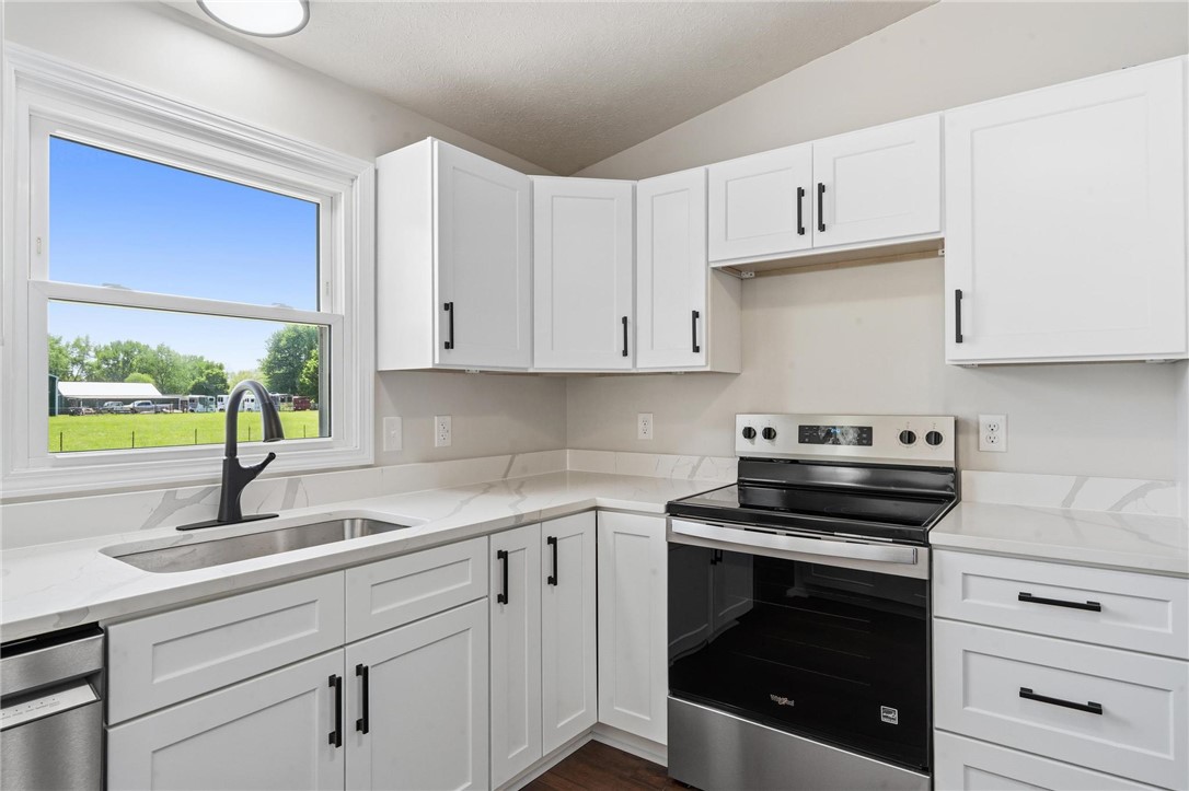 1353 Foust Road Xenia, OH 45385 - Photo 34 of 50 This modern kitchen features crisp white cabinetry and a view of the expansive outdoors.
