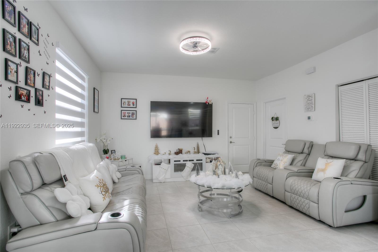 12911 Southwest 231st Terrace Miami, FL 33170 - Photo 4 of 15 a living room with furniture and a flat screen tv