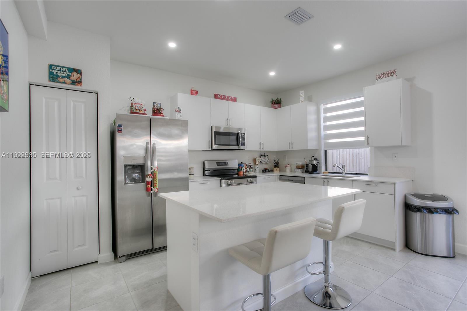 12911 Southwest 231st Terrace Miami, FL 33170 - Photo 5 of 15 a kitchen with refrigerator and chairs