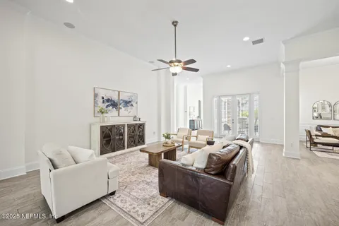 a dining room with furniture a chandelier and wooden floor