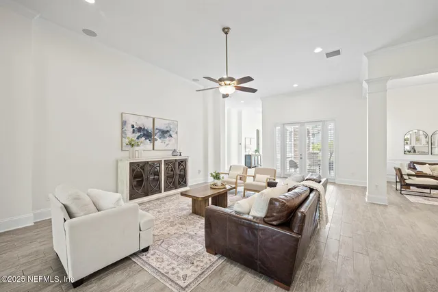 a dining room with furniture a chandelier and wooden floor