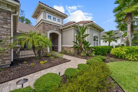 a front view of a house with a yard and potted plants