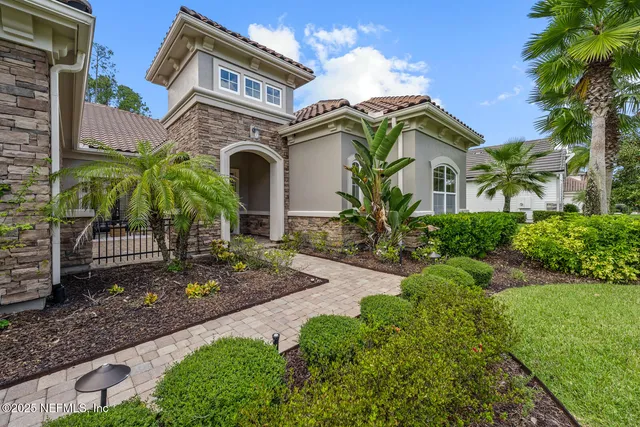 a front view of a house with a yard and potted plants