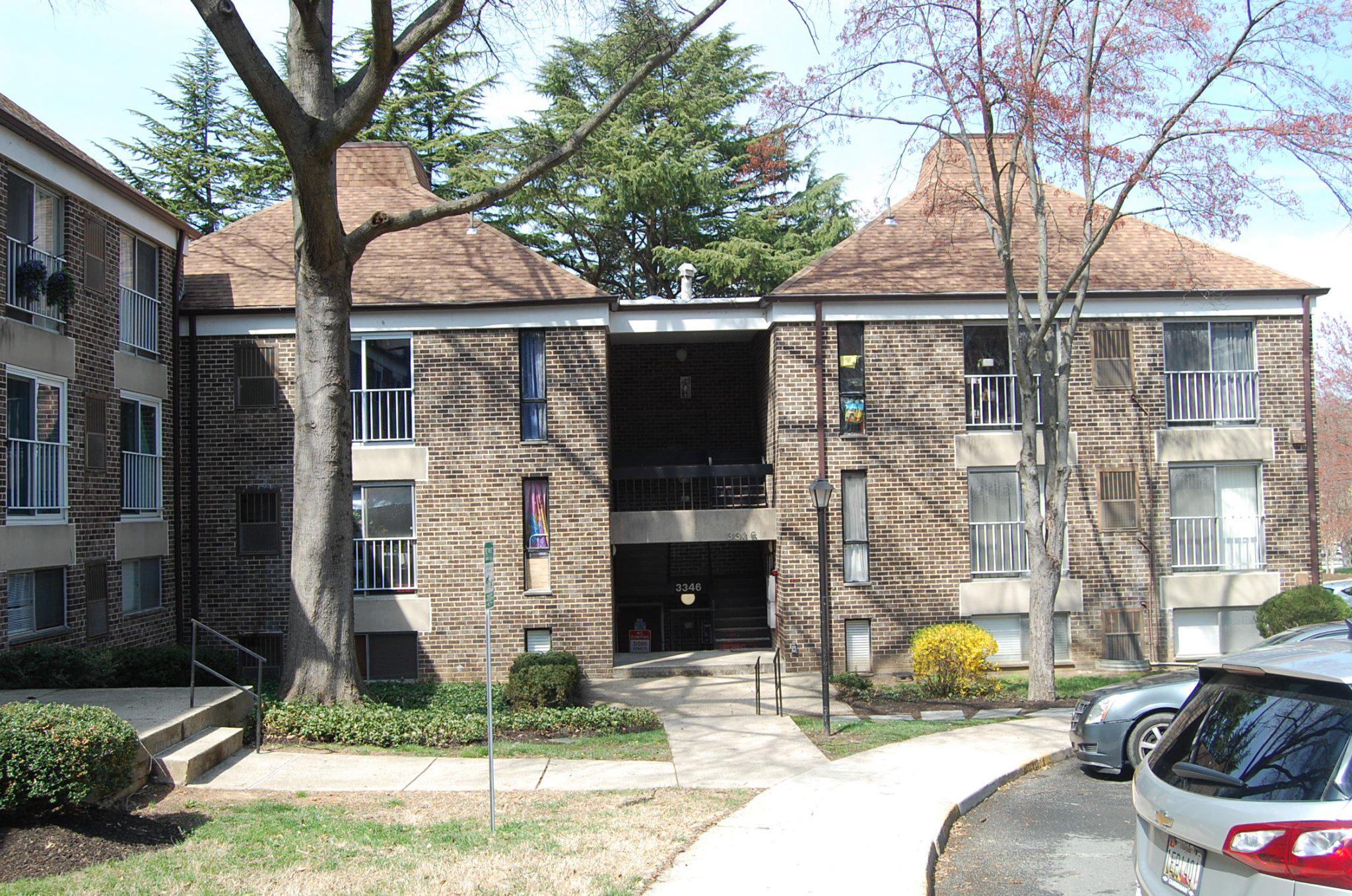 a brick house with tree in front of it