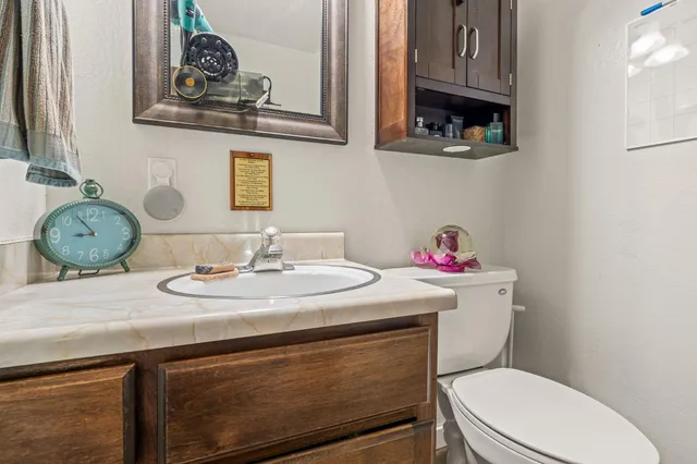 a bathroom with a granite countertop toilet sink and mirror