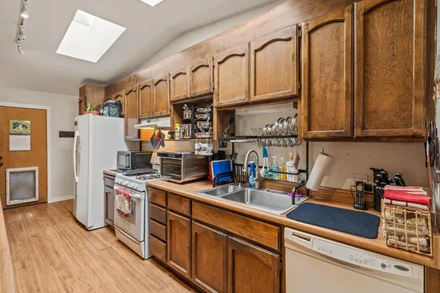a kitchen with stainless steel appliances granite countertop a sink a stove and refrigerator