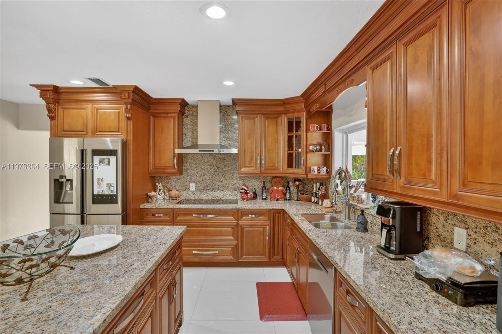 19390 Southwest 312th Street Homestead, FL 33030 - Photo 11 of 41 a kitchen with stainless steel appliances granite countertop a sink a stove and a wooden cabinets