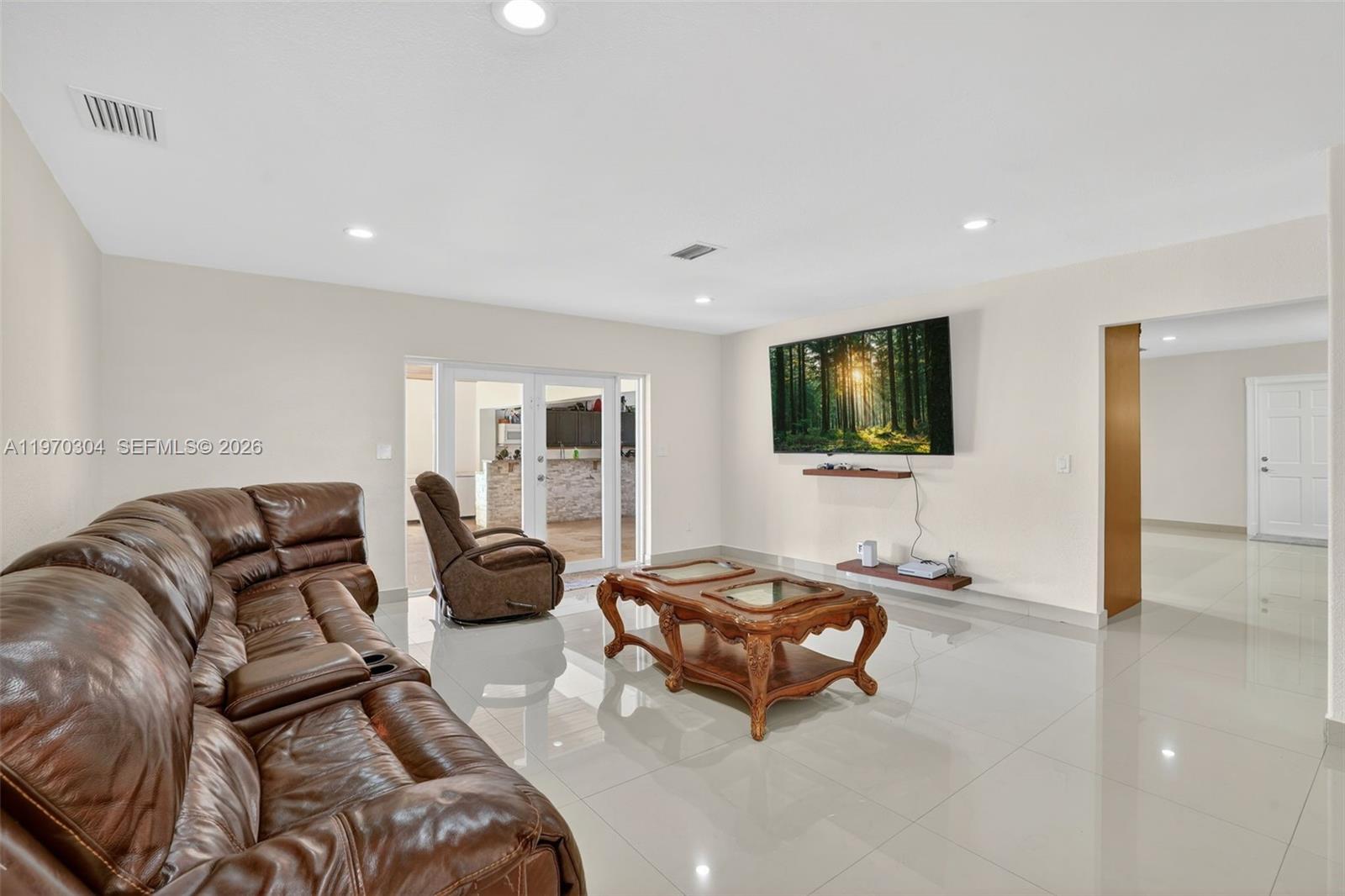 19390 Southwest 312th Street Homestead, FL 33030 - Photo 14 of 41 a living room with furniture a flat screen tv and a couch