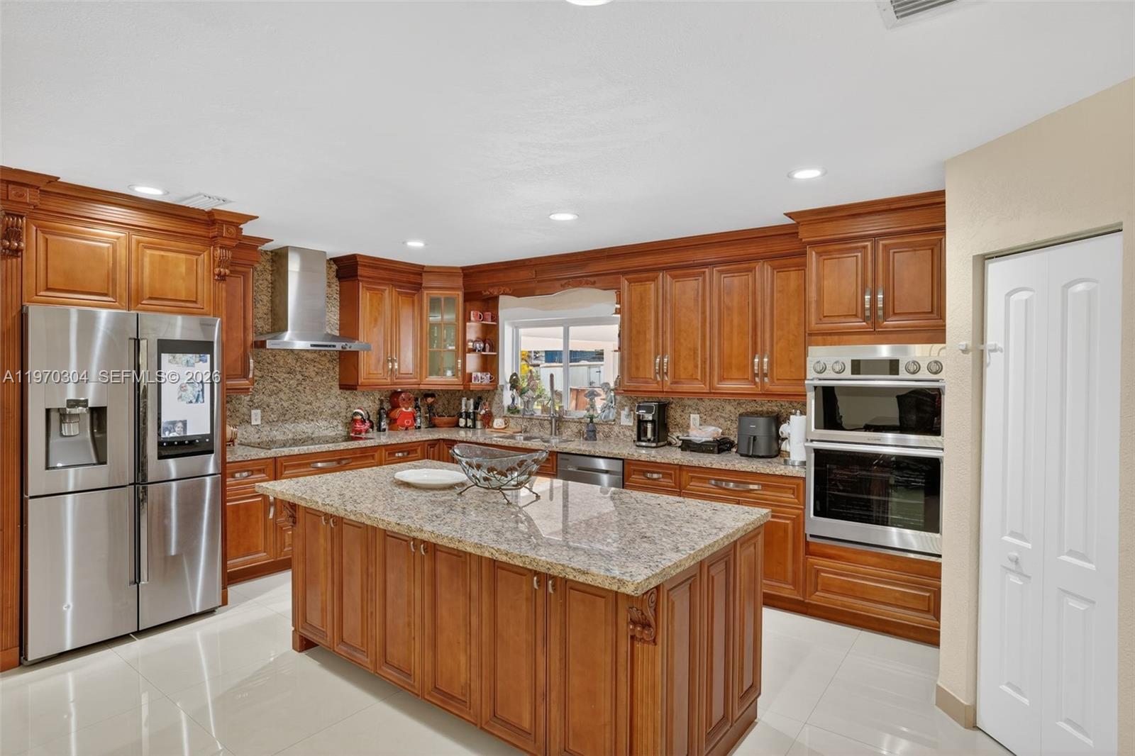19390 Southwest 312th Street Homestead, FL 33030 - Photo 15 of 41 a kitchen with stainless steel appliances granite countertop a sink stove and refrigerator