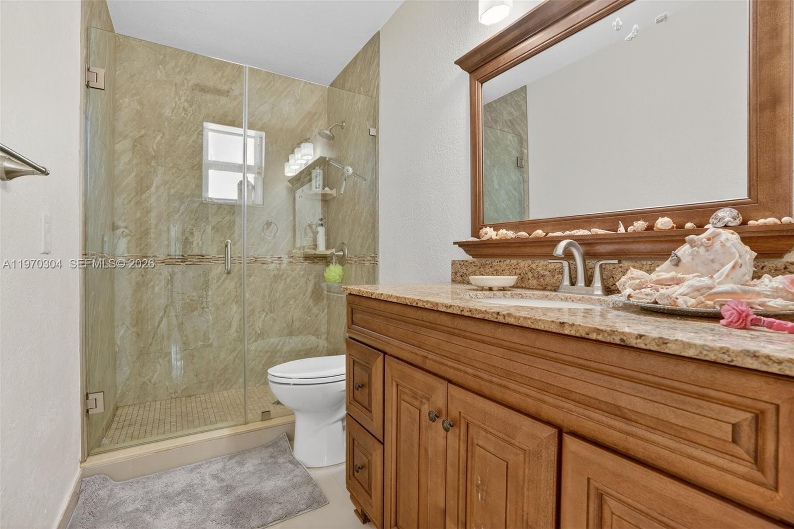 19390 Southwest 312th Street Homestead, FL 33030 - Photo 24 of 41 a bathroom with a granite countertop sink a toilet and shower