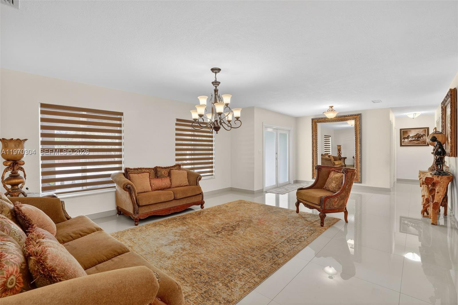 19390 Southwest 312th Street Homestead, FL 33030 - Photo 8 of 41 a living room with furniture and a chandelier