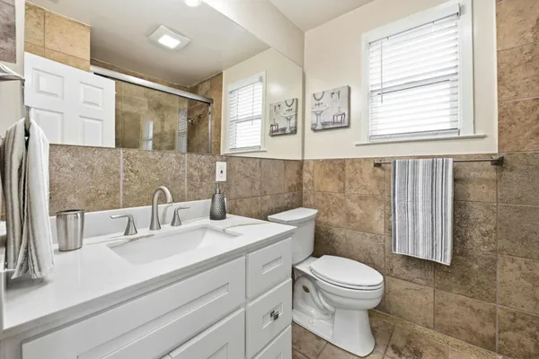 a bathroom with a toilet sink and mirror