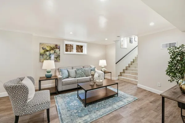 a living room with furniture and wooden floor