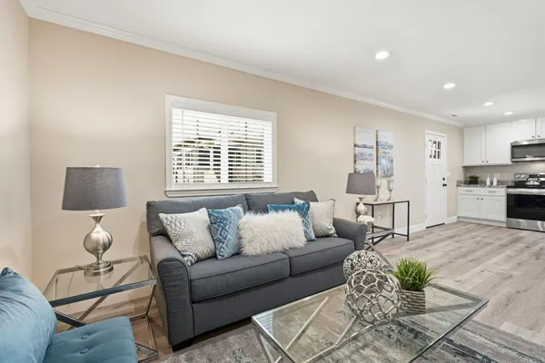 a kitchen with stainless steel appliances kitchen island granite countertop a stove a refrigerator and a dining table with wooden floor