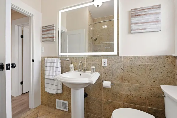 a bathroom with a sink a toilet and shower