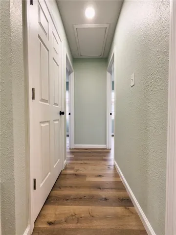 a view of a hallway with wooden floor and staircase