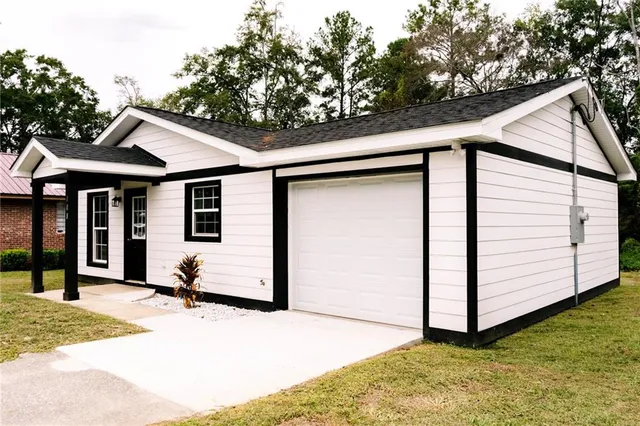 a white house with tree in front of it