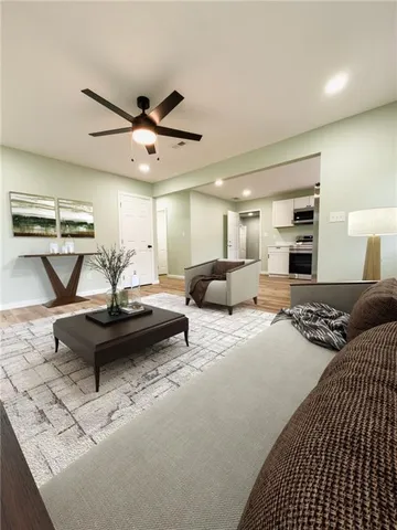 a living room with furniture and a ceiling fan