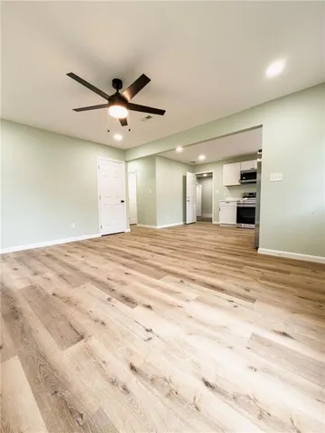 a view of a livingroom with a ceiling fan and kitchen view
