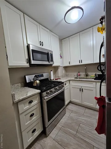 a kitchen with granite countertop cabinets stainless steel appliances and a sink