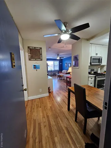a view of a dining room with furniture a chandelier and wooden floor