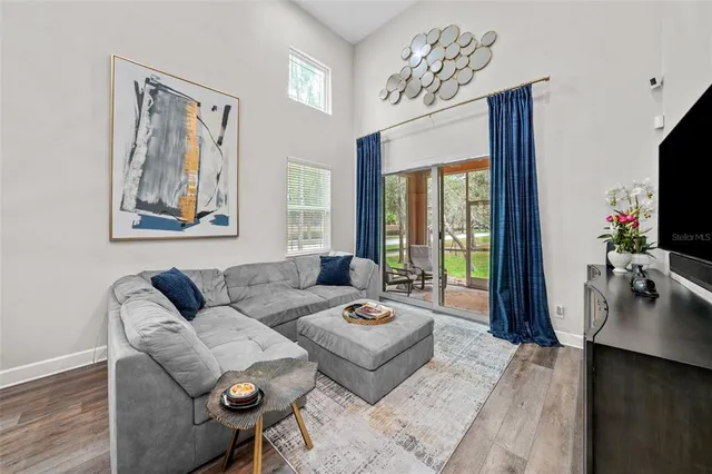 a living room with furniture a flat screen tv and a large window