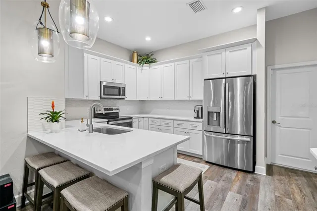 a kitchen with a refrigerator a stove a microwave and island with wooden floor