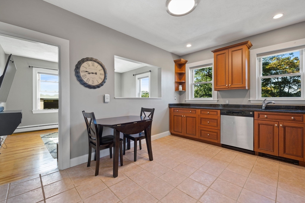 314 Water Street, Unit 5 Wakefield, MA 01880 - Photo 1 of 20 a kitchen with granite countertop a stove a sink a dining table and chairs