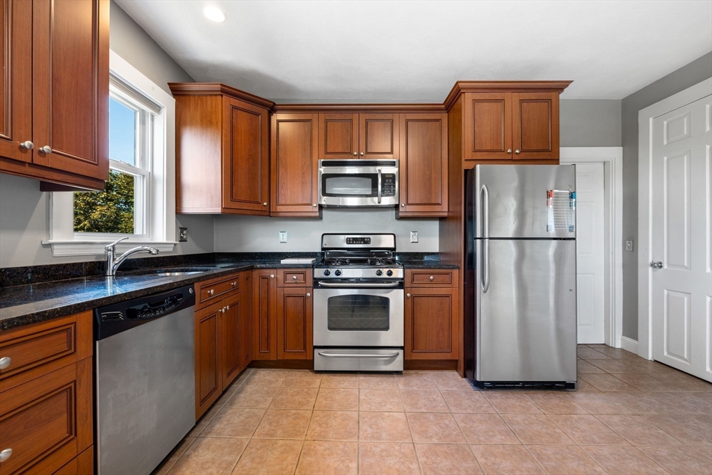 314 Water Street, Unit 5 Wakefield, MA 01880 - Photo 4 of 20 a kitchen with stainless steel appliances granite countertop a stove a refrigerator and a sink