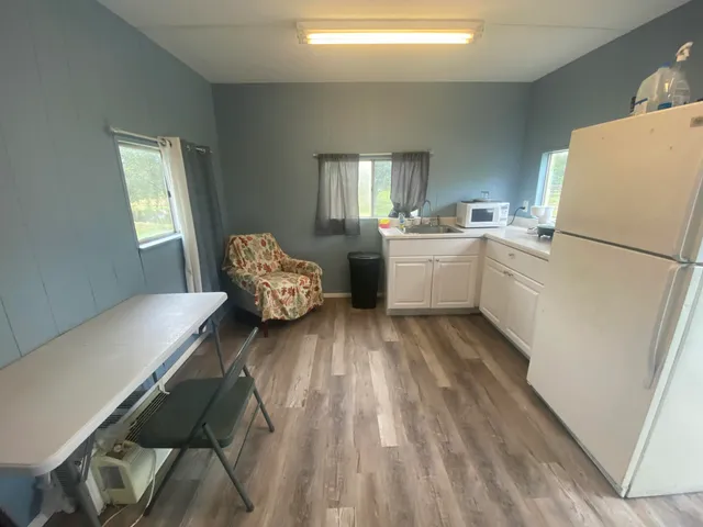 a kitchen with a refrigerator and white cabinets
