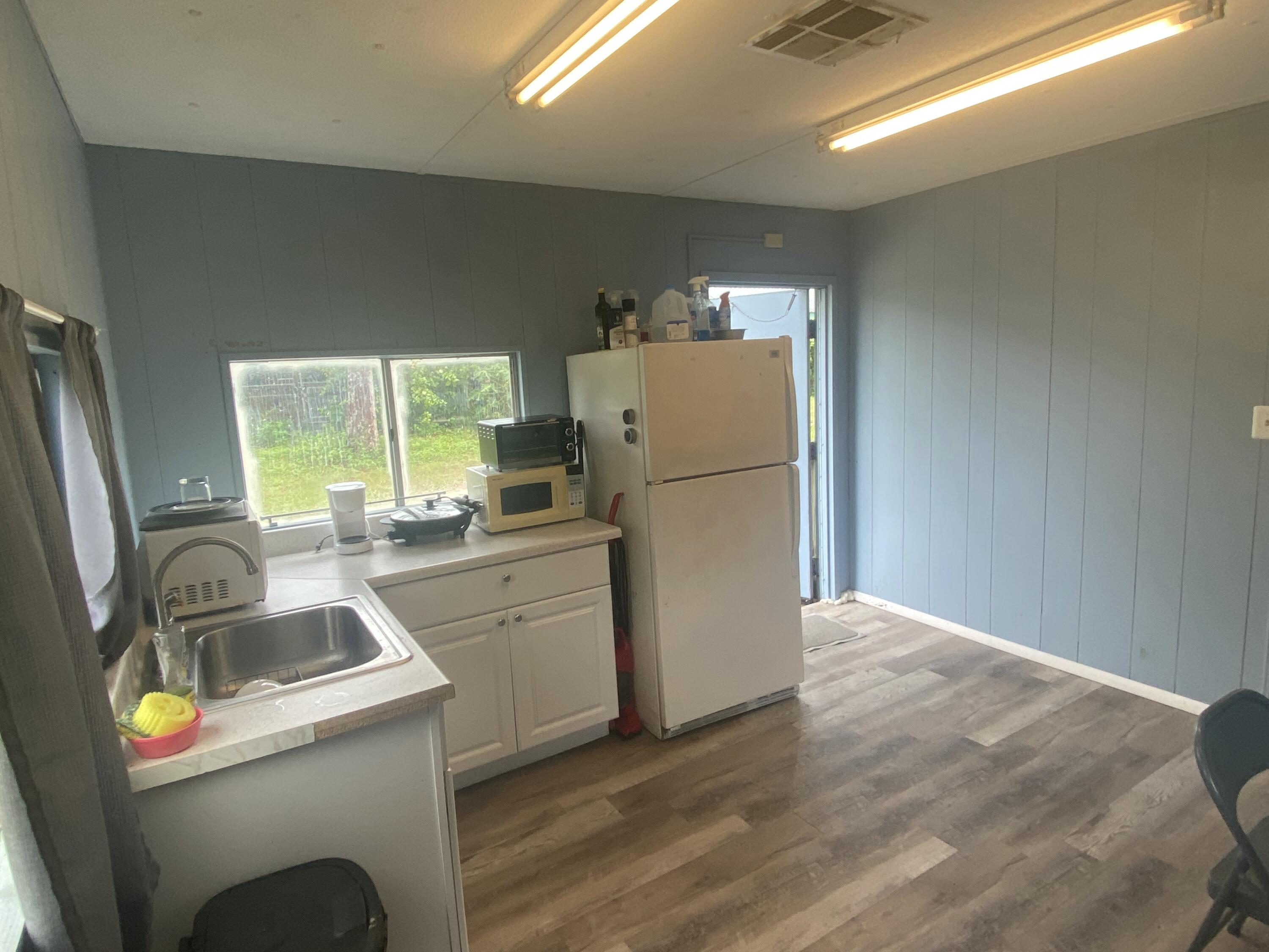 2141 B Road, Unit 4 Loxahatchee Groves, FL 33470 - Photo 4 of 43 a kitchen that has a sink and a refrigerator