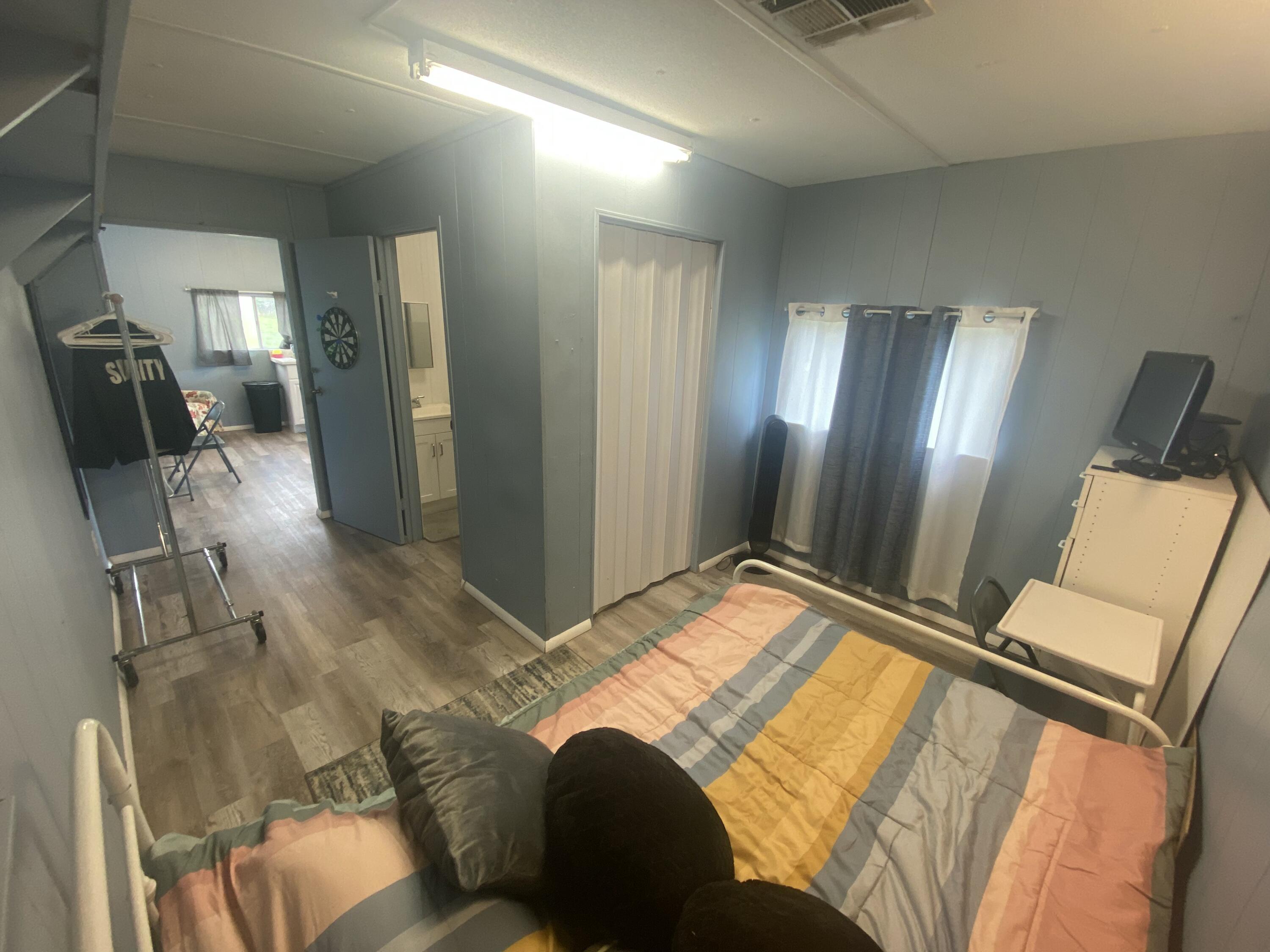 2141 B Road, Unit 4 Loxahatchee Groves, FL 33470 - Photo 8 of 43 a bedroom with a bed and wooden floor