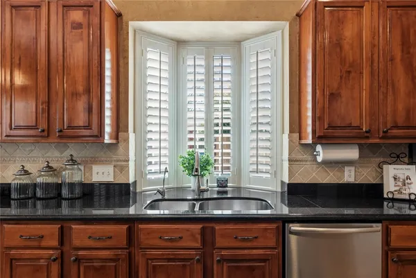 a kitchen with stainless steel appliances granite countertop sink stove top oven and cabinets
