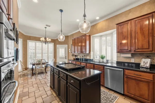 a kitchen with stainless steel appliances kitchen island granite countertop a stove a sink and a microwave