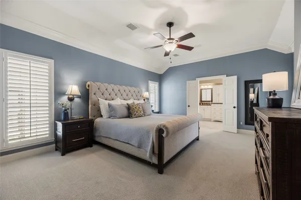 a spacious bedroom with a large bed and a chandelier