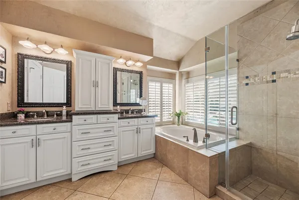 a bathroom with cabinets granite countertop a sink and a mirror