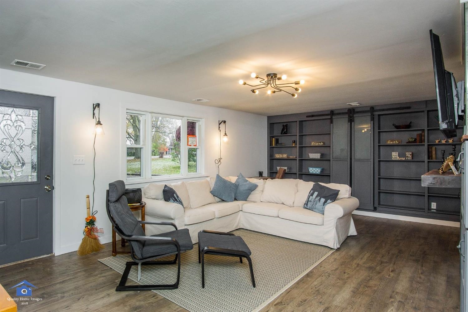 10807 Porter Street Crown Point, IN 46307 - Photo 4 of 10 a living room with furniture a chandelier and a flat screen tv