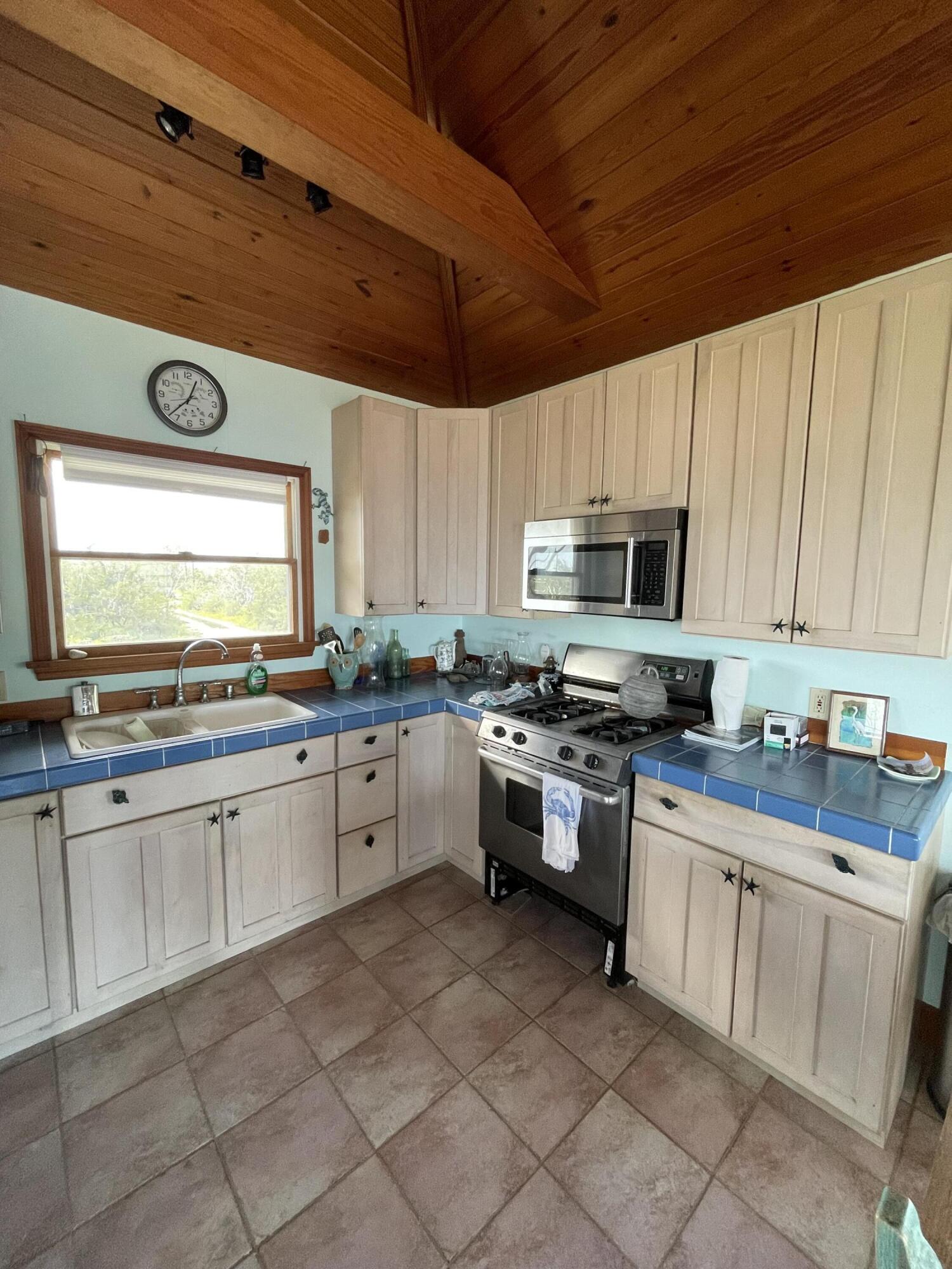 31625 Warner Street Big Pine Key, FL 33043 - Photo 19 of 30 a kitchen with white cabinets and white appliances